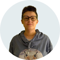 Портрет Ивы Кочневой в анфас. Женщина средних лет смотрит прямо на зрителя: у неё тёмно-каштановые волосы, уложенные в короткую стрижку, карие глаза и немного смуглая кожа. Она одета в голубую толстовку с изображением рыси, в кадре видна только верхняя часть изображения с ушами и лбом зверя